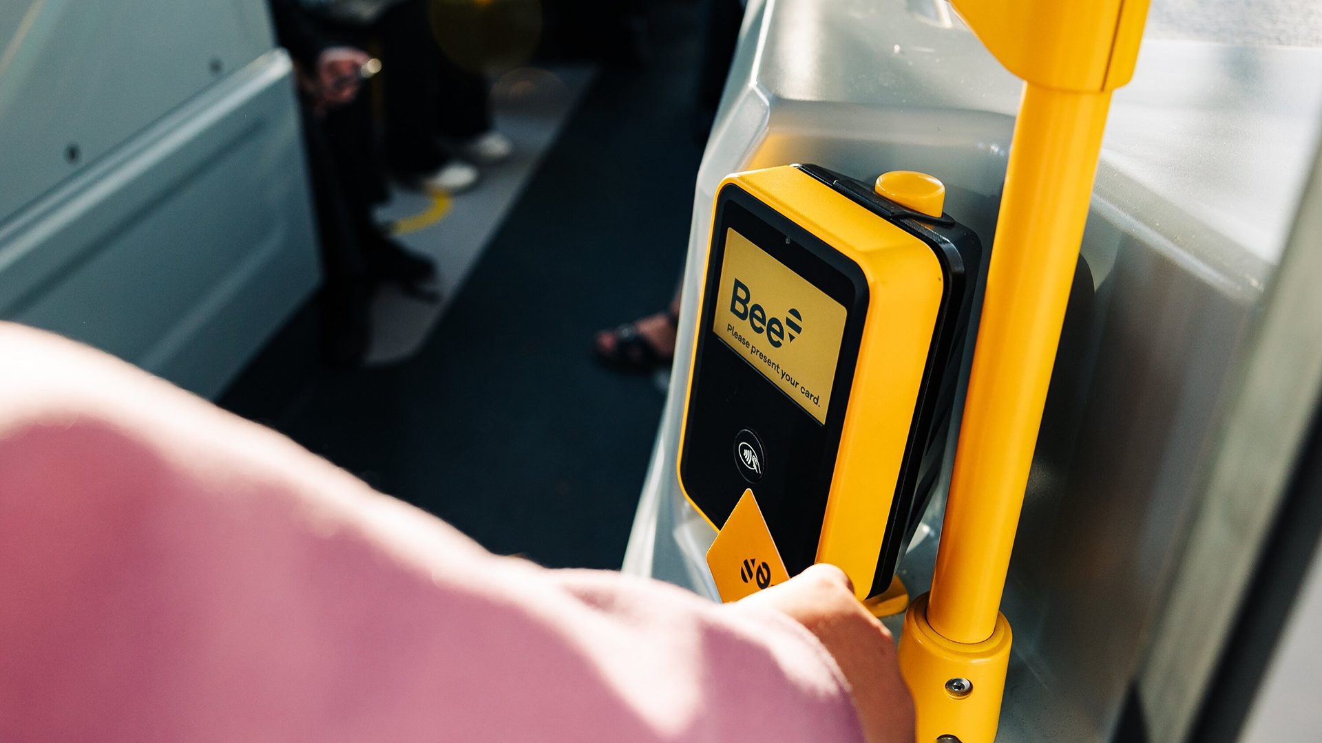 Bus user tapping their yellow bee card to get on the bus