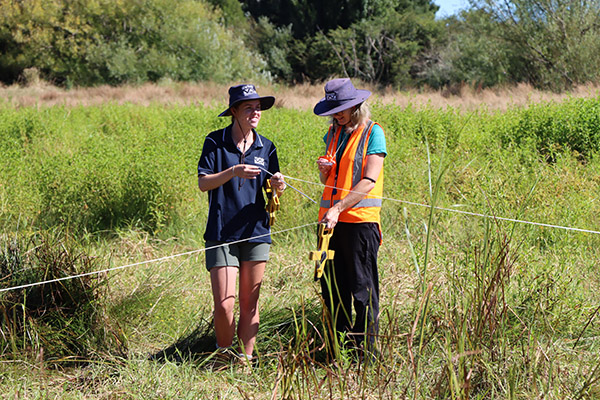 Image - Summer student Ayla Vette and ecology scientist Dr Liz Overdyck set up a corner of the monitoring plot.