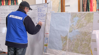 Exercise controller reviewing a map during the Kārewa response briefing