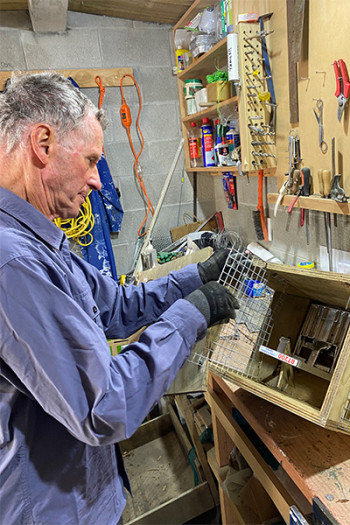 Dennis works on a trap in his workshop
